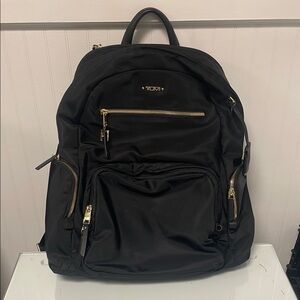 Tumi Black Backpack with Gold Zippers and Padded Straps